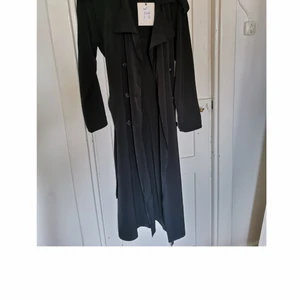 Svart kappa - Svart lång tunn kappa från bikbok, aldrig använd med lappen kvar. Nypris 599kr. 