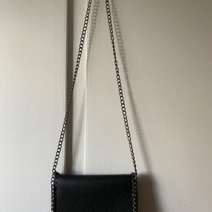 Väska  - Axelbands väska med kedja  Svart  Finns ett innerfack mad dragkedja och ett fack utan  Ej äkta! 