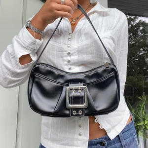 svart axelremsväska - snygg och praktisk axelremsväska med fina detaljer! får plats med det nödvändigaste. använd endast ett par gånger. vet inte märket!