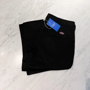 Svarta byxor från Dickies  - Svarta byxor från Dickies. Köpta via Sellpy i perfekt skick. Säljes pga för stora.   (OBS! Storleken är midja.)