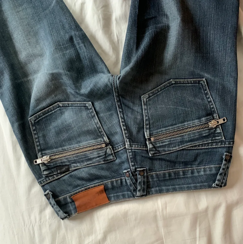 Snygga lågmidjade jeans från blend med kedjor på bakfickorna. Använda men i ok skick. Säljer vid bra pris . Jeans & Byxor.