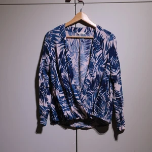 Blue/white blouse with palm design - Blouse in blue and white with a palm pattern. Blouse js closed at the bottom, falls very elegantly. In perfect condition. 
