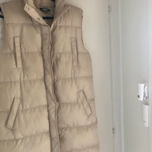 Lång dunväst - Aldrig använd köpt från Nelly.  Beige 