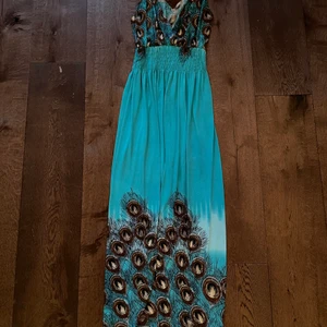 Fin sommarklänning  - Turkos mönstrad långklänning, bekvämt luftigt tyg och snygga detaljer i ryggen