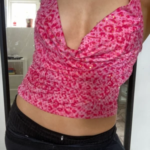 Rosaglittrig topp - Säljer denna supersnygga rosa topp med glitterdetaljer. Knyts baktill i stretchigt material.