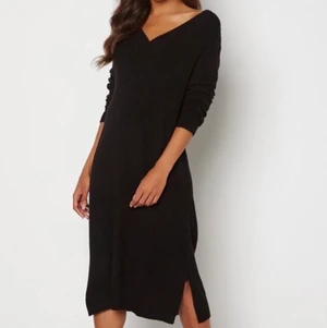 Svart klänning - Svart stickad klänning med liten slits, V-ringad