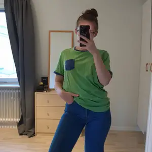 Grön t-shirt med blåa kanter och ficka