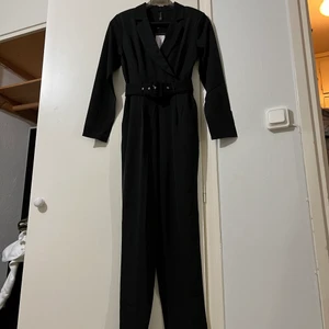 NY jumpsuit, kostymtyg - Den perfekta svarta kostymjumpsuiten. Raka/tighta ben och bra passform. Helt ny, prislappar kvar. 