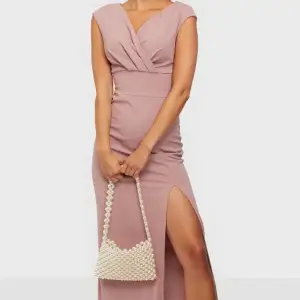 Rosa balklänning med en V-ringad form framtill, slits