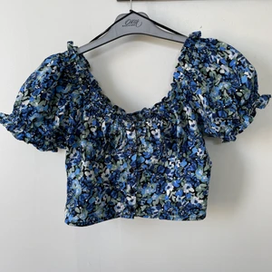 Blå sommartopp  - Jätte snygg somrig blå topp med fina detaljer på axlarna! I väldigt fint skick! 