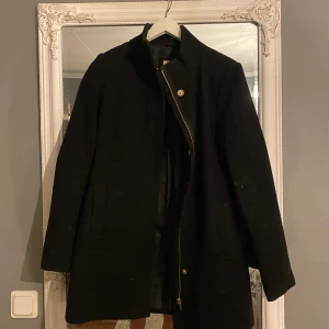Svart kappa - Säljer min gamla favorit kappa då jag inte rymmer i den längre. Allt är intakt på den utom att jag har tappat bort det svarta bandet som är till. Den är väldigt fin och har en extremt bra passform. Nypris 1499kr