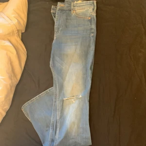 Blåa flared jeans med hål - Färgen är mer blå irl än på bild, storleken är 28/30 alltså 28 midjemått och 30 längd. Sparsamt använda och i mycket fint skick!