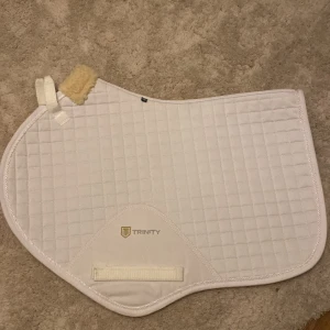 Trinity schabrak storlek ponny - Jag säljer nu mitt snygga vita trinity schabrak i storlek ponny!🥰 Schabraket är helt oanvänt och har inga repor eller skråmor, det har bara legat hemma i en garderob. 💞Nypris: 500kr Mitt pris: 250kr! 🥰
