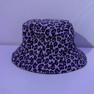 Tvåsidig/vändbar buckethat!! 2 i 1! Ena sidan är lila och svart leopard mönster och den andra helt svart💫 perfekt skick