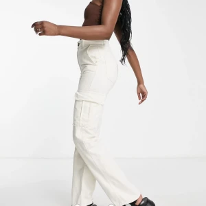 Gräddvita cargobyxor med raka ben strl 42 - Jag har köpt de hära byxorna men de var för små så jag lämna aldrig tillbaka de men de har även prislappen kvar!! 