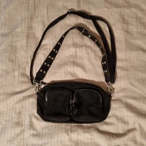 Svart väska  - Säljder denna svarta väska som är använd fåtal gånger. Den har 2 band som är avtagbara.