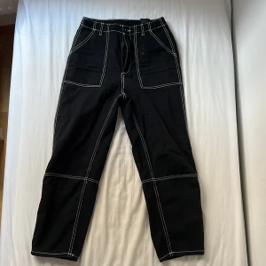 Svart vita cargo pants - Cargo byxor från H&M i mycket bra skick förutom ett par lösa trådar som knappast syns. Använda 1 gång.   Original pris: 300kr Frakt: 29kr