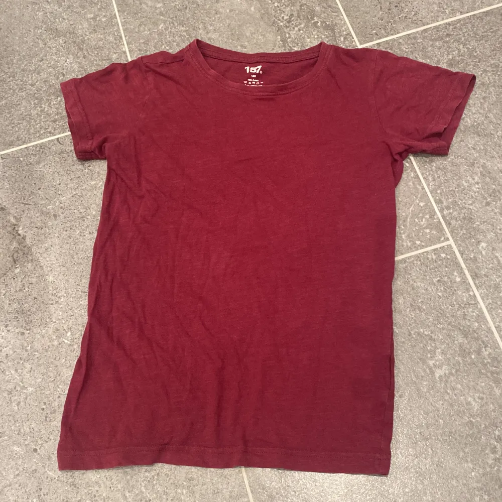 En vinröd T-shirt i strl 140 från lager 157. Fint skick⭐️. T-shirts.
