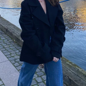 Svart Kort Kappa - Lägger upp igen pågrund av oseriös köpare❗️❗️Kappa fyndad second hand från märket Cube! Storlek 38, sitter lite oversized på mig som normalt har storlek 34/36, men perfekt för vintern för tjocka tröjor att ha under!🤩 säljer för har hittat en liknande i en a