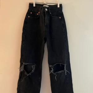 Svarta jeans från ginatricot  - Svarta jeans med hål på knäna från ginatricot. Storlek 30 petite. Är bra i längden för mig som är 161.