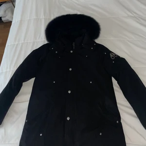 Moose Knuckles Jacka - Moose Knuckles jacka, tonåring modell. Storlek XL Teenager. Passar folk med XS elr S. Svart, Moose Knuckles loggan är silver metall. Riktigt bra skick även. Svart päls också. 
