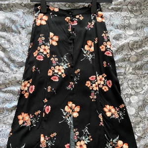 Kjol med slits  - Super söt kjol från H&M i storlek 34!! Knappt använd, nyskick. Har en slits på varje sida samt knappar ner till lite mer än halva kjolen fram.