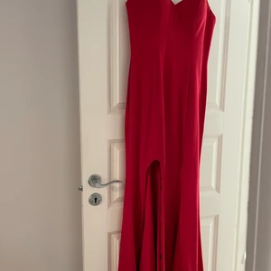 AFTON/BALKLÄNNING - Röd aftonklänning med hög slits. Litet släp baktill.  Storlek S Använd en gång, nypris 2799:- 