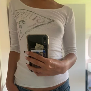 Guess tröja  - Guess tröja, i fint skick. Ärmarna slutar vid armbågen och det är en urringning i ryggen