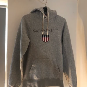 Gant hoodie - Gant hoodie storlek xs i bra skick. Den har använts fåtal gånger och senast för ca ett år sedan. Har en liten reva som är lagad (se bild 3) annars inga defekter. 60kr eller bud i pm 