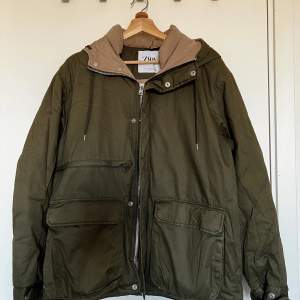 Great winter jacket with hoodie and many large pockets. 100% polyester, large fit. 