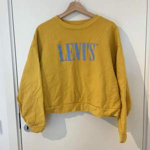 Gul cropped Levis sweatshirt med blå logga. Fint skick. 