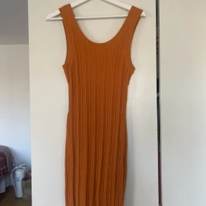 Klänning  - Orange klänning från & other stories i storlek M. Klänningen är använd 2-3 gånger. Den går till ovanför knäna på mig som är 176 cm.