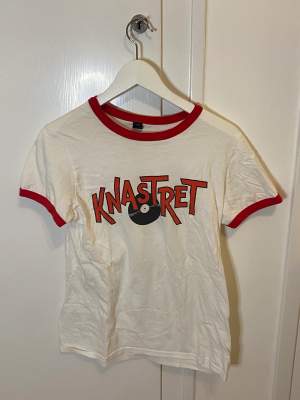 Vit och röd T-shirt med tryck ”knastret” från ANVIL. Sälj pga att den inte använts på länge🫶🏻I ny skick💗
