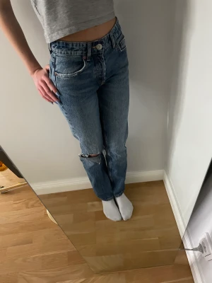Zara jeans  - Säljer mina jeans från zara som är midrise i storlek 32 o är märkblåa med ett hål vid knät💓