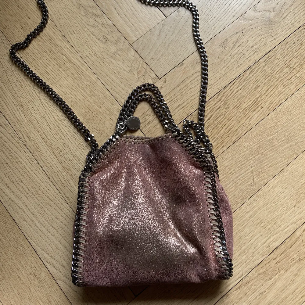 Säljer min jättefina rosaglittriga Stella Mccartney väska.💖 Modell: Falabella. Storlek: Tiny. Den har en del defekter på utsidan och kedjan. Skriv för fler bilder📸. Väskor.