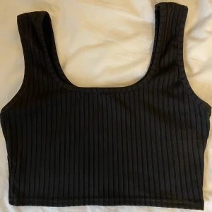 Kort svart topp - Ribbad snygg topp från Parisian, köpt på Nelly. Aldrig använd. Snygg under kavaj! Stretchigt ribbat tyg