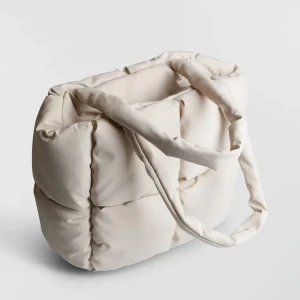 padded väska - helt ny väska med tags ”jamie padded” från gina tricot - väldigt ljust beige - stängs med dragkedja - köpt för 380kr - mått:  Höjd 28cm Bredd 28cm Djup 12cm