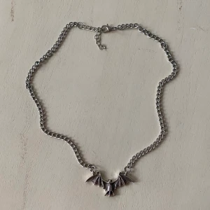Fladdermus halsband - Fett coolt halsband med en fladdermus som motiv. Man kan justera storleken. Snyggt till de flesta outfits. För fler bilder eller mått kontakta mig! Frakt 13 kr frimärke vid köp med swish.