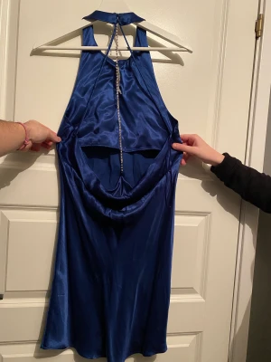 Öppenrygg klänning ZARA Storlek M - Helt oanvänd festklänning från Zara i storlek M. Halterneck, öppen rygg med silvrig glitterkedja i färgen marinblå. Lite mindre i storleken 