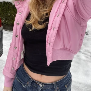 Croppad rosa jacka - Rosa jacka med päls. Inte särskilt varm, men söt. Andra bilden lånad. Uppskattad storlek XS. Frakt tillkommer