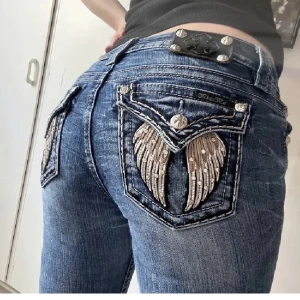 Lågmidjade Miss Me jeans - Säljer mina lågmidjade Miss Me jeans med tryck som är köpa här på Plick för att de var lite för stora i midjan för mig. Jag är storlek xs/s, 167cm. Kontakta mig om du vill köpa🤗🤗(lånade bilder) Innerbensmptt: 76cm 
