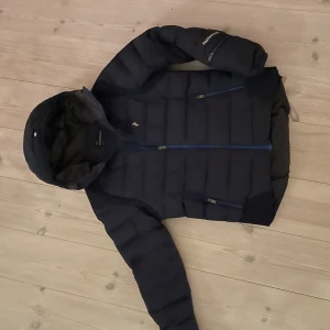 Dunjacka från Peak Performance. - Snygg Peakjacka för skidåkning eller vardag, mycket detaljer och bra funktioner.