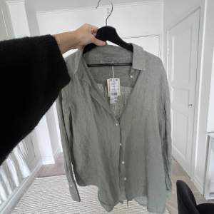 En grön linneskjorta från Ginatricot i storlek 40❤️aldrig använd och har kvar prislappen, ordinarie pris 349 kr🫶🏼🫶🏼