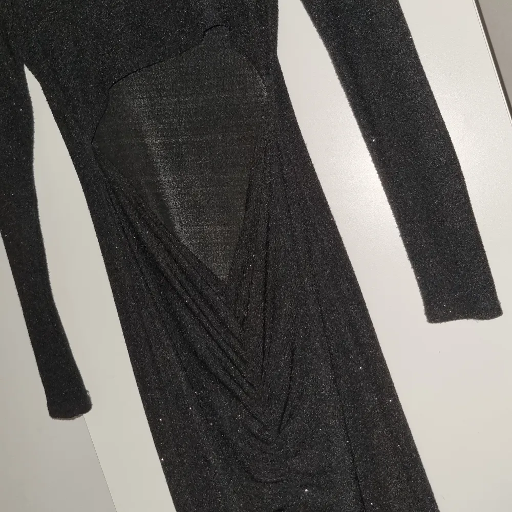 En glittrig lång klänning där ryggen är öppen vid svanken. Använd 1 gång. Köparen står för frakt (99kr). Klänningar.