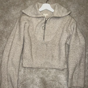 Tröja - Stickad tröja i beige färg med dragkedja. Storlek  XS Tröjan är i bra skick. 