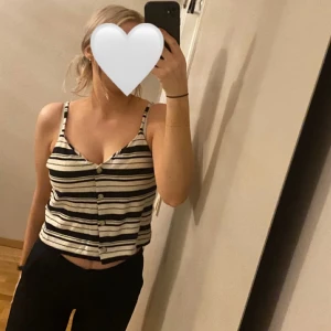 Randig sommartopp - Supersöt randig sommartopp med knappar. I nyskick och sparsamt använd.