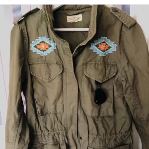 Jack Ralph Lauren  - Snygg militärgrön jacka från Ralph Lauren Denim & Supply. Luva finns att fälla ut i kragen. Även snören i midjan för att få en kvinnligare touch. Nyskick. Rökfri. Detaljer med pärlor. 100% Bomull. Vår & sommar jacka. 