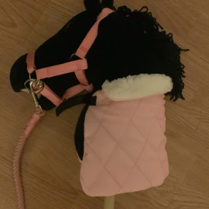 En svart och en vit käpphäst + redskap - Jag säljer en svart häst med knapp ögon och en garn man och en vit enhörning men insytt rosa  och stjärnigt träns. Sen säljer jag ett svart träns och jag säljer allt tillsammans.