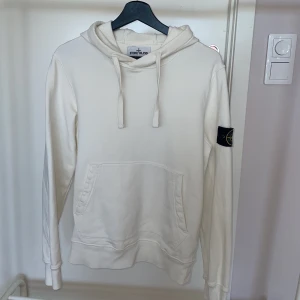 Stone Island hoodie - Vit Stone Island hoodie i herrstorlek S. Nypris runt 3000kr, säljes för 1600kr. Jättefint skick, köpt på NK i Göteborg och kvitto finns!