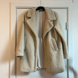 Teddykappa Gina tricot - Teddykappa från Gina. Använd men i bra skick. Storlek 40, frakt tillkommer